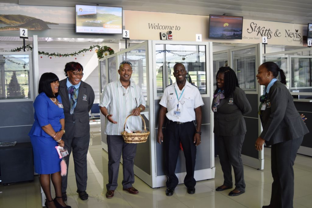 Officer on Duty at the Sandy Point Police station surpised by Commissioner Queeley bearing a Christmas Treat